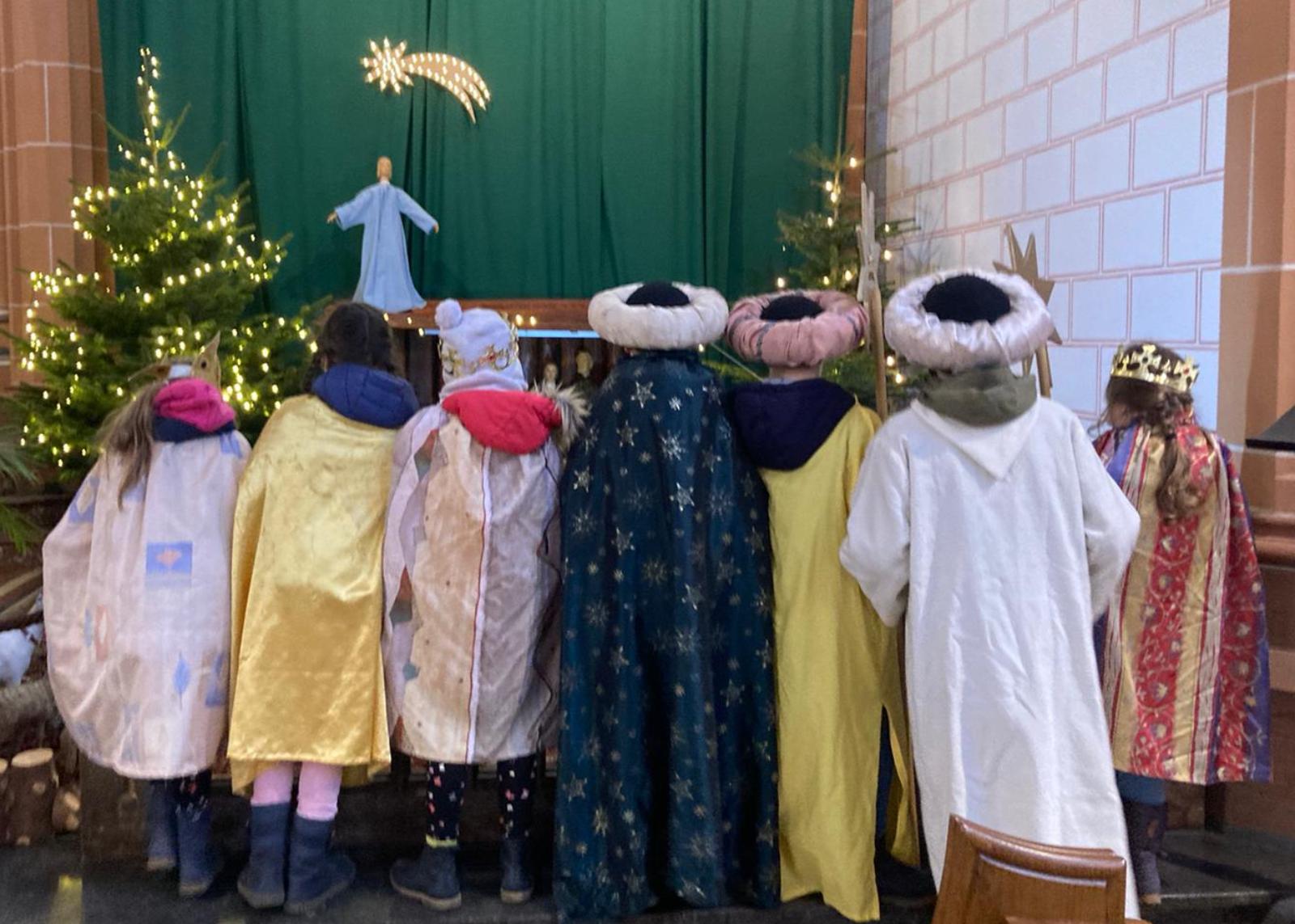 Sternsinger vor der Krippe von St. Peter